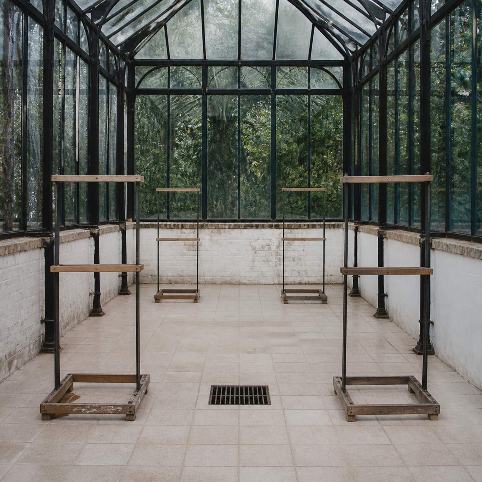 A clean, bare quarantine room with tiled floor and empty perching frames